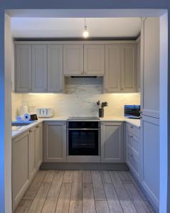 a white kitchen with white cabinets and an oven at Dale View in Youlgreave