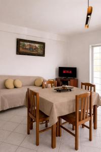a living room with a table and a couch at Pelekanos Apartment in Paralia Saranti