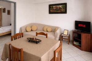 a living room with a table and a couch at Pelekanos Apartment in Paralia Saranti