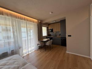 a bedroom with a bed and a table and a kitchen at MOREHOME Zentral Parkplatz Balkon nähe Therme in Bad Wörishofen