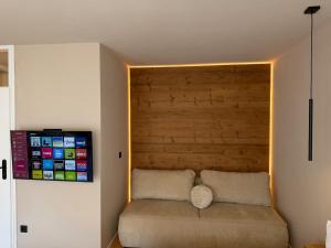 a room with a couch with a wooden headboard at MOREHOME Zentral Parkplatz Balkon nähe Therme in Bad Wörishofen