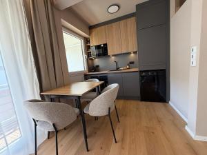 a small kitchen with a wooden table and chairs at MOREHOME Zentral Parkplatz Balkon nähe Therme in Bad Wörishofen +3 photos
