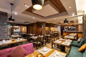 a restaurant with tables and chairs and a bar at Inti Punku Machupicchu Hotel & Suites in Machu Picchu