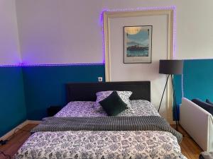 a bedroom with a bed with purple and blue walls at Urban Grand Suite in Berlin