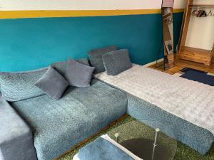 a couch with pillows on it in a room at Urban Grand Suite in Berlin +2 photos