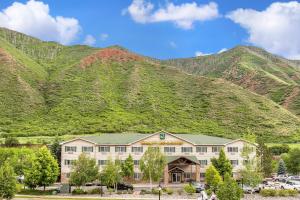 a hotel with a mountain in the background at Quality Inn & Suites On The River in Glenwood Springs