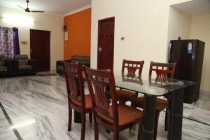 a dining room with a glass table and chairs at Sudha Grand Guestinn in Nellore