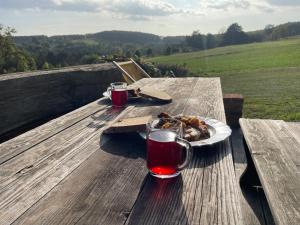 a plate of food on a wooden table with a drink at Das Weinstöckl in Inzenhof