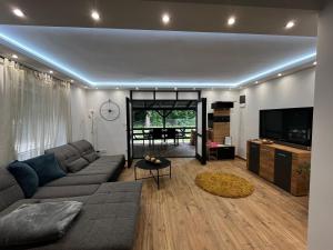 a living room with a couch and a tv at Bay House Balaton in Balatonfůzfő