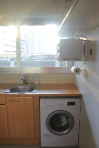 a kitchen with a washing machine and a sink at Moderne Apartement La Defense Paris in Courbevoie