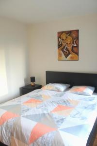 a bed with a colorful quilt on it in a bedroom at Moderne Apartement La Defense Paris in Courbevoie