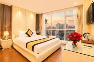 a hotel room with a bed and a large window at Golden Star Hotel in Ho Chi Minh City