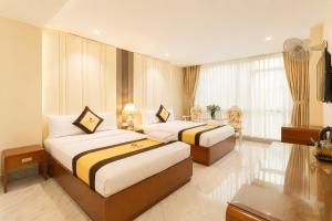 two beds in a hotel room with a room at Golden Star Hotel in Ho Chi Minh City