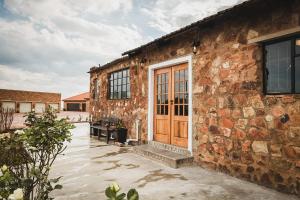 a stone building with a wooden door and a bench at Die Kliphuis in Klerksdorp