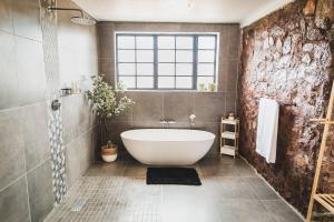 a bathroom with a white bath tub and a window at Die Kliphuis in Klerksdorp