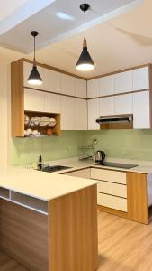 a kitchen with white cabinets and a counter top at Homestay MinhQuân86 in Kon Rung (1)
