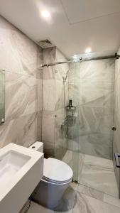 a bathroom with a toilet and a glass shower at Homestay MinhQuân86 in Kon Rung (1)