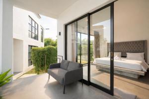 a bedroom with a bed and a chair at Villa Valeria in Uluwatu +65 photos