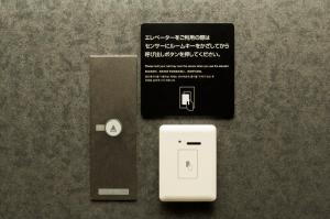 a white electrical outlet next to a black box at Dormy Inn Premium Kyoto Ekimae Natural Hot Spring in Kyoto