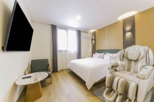 a hotel room with a bed and a tv at 군산 비욘드 호텔 in Sinp'ung