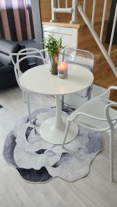 a white table and chairs with a candle on a rug at La Casa Verde in Seoul