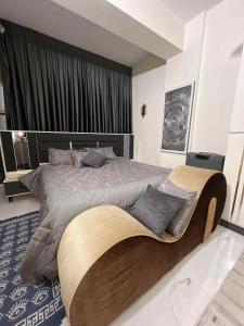 a bedroom with a large bed with a wooden headboard at Carmel Residence - كارمل ريزيدنس in Baghdād +146 photos