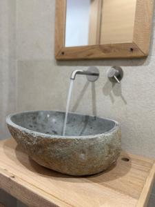 a stone sink sitting on a wooden cutting board at Alkyonis Apartment Milos in Triovasálos