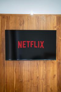 a netflix sign on top of a wooden wall at Sachi Guest House in Jimbaran
