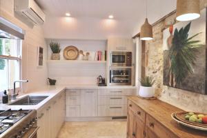 a kitchen with white cabinets and a sink and a counter at Mr Banks in Robe +12 photos