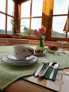 a table with a plate and a cup and fork and knife at Weingut Gaube in Leutschach