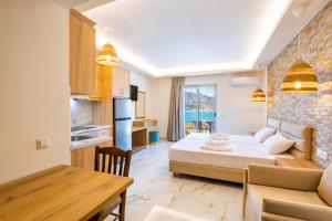 a room with a bed and a table and a kitchen at Dolphin Hotel Apartments in Karpathos