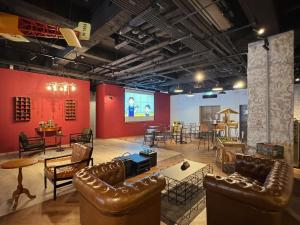 a large room with leather furniture and a screen at Mazor Hotel Hualien Linsen in Hualien City