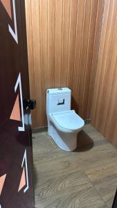 a bathroom with a toilet in a wooden door at Athulya Tropical Paradise in Paravūr