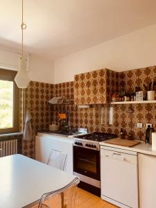 a kitchen with a stove and a table in it at Villa Fiorentino in Ivrea