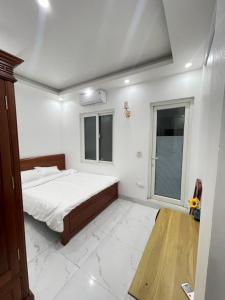 a white bedroom with a bed and a window at Anna's House - Hoa Lư in Ninh Binh