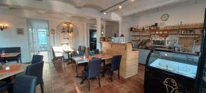 a restaurant with tables and chairs and a fish tank at "Nesthocker" Café-Snackbar-Pension-Bauwagencamp in Offingen