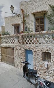 a motorcycle parked in front of a stone building at Rustic-style apartment in LMP
