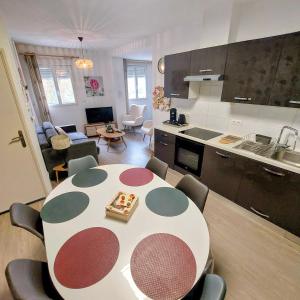 a kitchen and a table and chairs in a room at gîte 65 m2 200 m gare t-g-v et fac 400 m centre-ville grand parking 250 places gratuit face au logement in Arras
