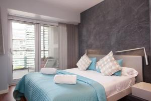 une chambre avec un lit avec des oreillers bleus et blancs dans l'établissement Rent Top Apartments Beach-Diagonal Mar, à Barcelone