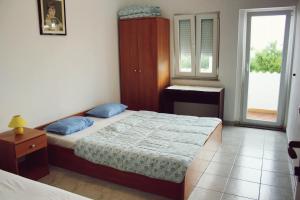 a small bedroom with a bed and a window at Panorama Apartments in Povljana +99 photos