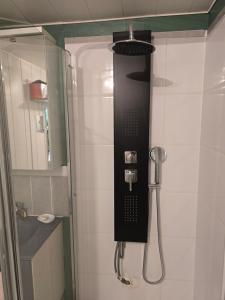 a shower in a bathroom with a black phone on the wall at Studette avec terrasse privée in Saint-Raphaël