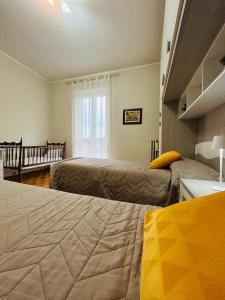 a bedroom with two beds and a window at Casa Flora in Biella