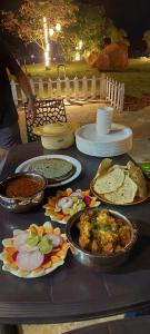 a table topped with different types of food on plates at Harmony Hills in Bhīra Camp