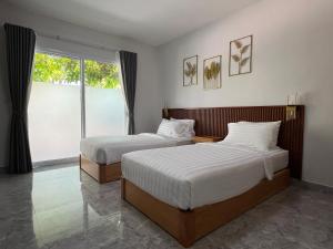 a bedroom with two beds and a large window at Wilawan home in Ko Samui