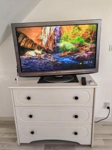 a tv sitting on top of a white dresser at Séjour près de Bayeux avec Massages et repas en options in Tilly-sur-Seulles