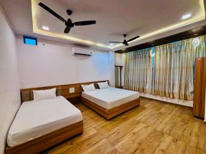 a bedroom with two beds and a ceiling fan at Fairview Anayaa in Khātu
