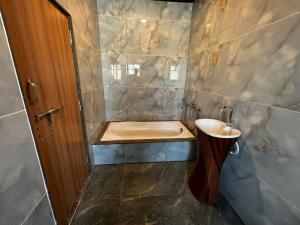 a bathroom with a tub and a sink and a toilet at Fairview Anayaa in Khātu