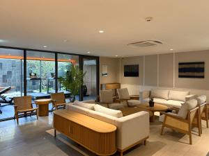 a living room with couches and chairs and tables at Laguna Seaside 3 bed #84195 in Bang Tao Beach