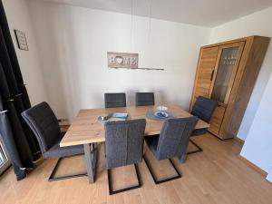 a dining room with a wooden table and chairs at Achterdeck Kajüte in Dornumersiel