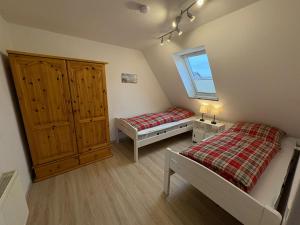 a small bedroom with two beds and a window at Achterdeck Kajüte in Dornumersiel